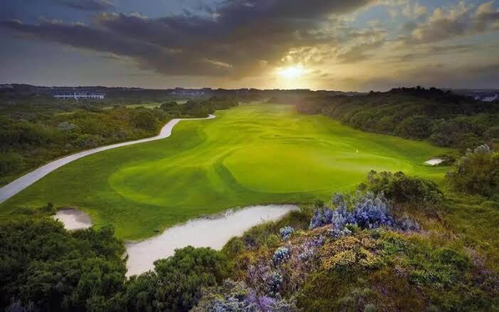 Sunset over a St Francis Links fairway framed by flowering fynbos