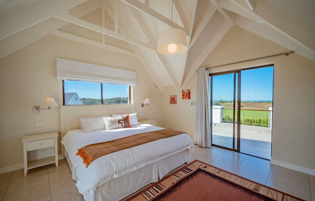Bedroom made up as a king, with vaulted white ceiling and doors to the terrace